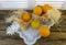 Still life with oranges, basket and glass jug with juice on old  wooden background