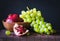 still life with pomegranate and green grapes on a dark background