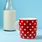 Still life with red, in polka dot, cup of milk and vintage glass bottle