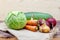 Still life of ripe vegetables on sackcloth. Cabbage, zucchini, pumpkin, carrots, beets and onions on wooden table