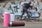 A still-life of several used paint cans of different colors against the graffiti wall