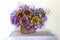 Still life with sunflowers and blue flowers on a white background.