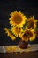 Still life with sunflowers in a clay pot against a wooden wall