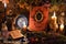 Still life with tarot cards, crystal ball, candles and witch book with hanging herbs on table