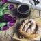 Still life with tulips, book, coffee and pretzel on wooden background