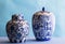 Still life with two blue and white ceramic ginger jars isolated on blue