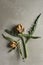 Still life of two small dried artichoke globes on stems with leaves