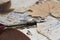 Still life. View of old handwritten notes on stained papers. Dried leaves. Quill.