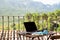 Still life view of open laptop computer on a wooden patio patio table with mobile headphones and notepad in outdoor home area,