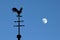 Still life of weathercock and moon in blue sky