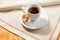 Still life with a white cup of coffee with foam at the background of the vintage homemade napkin