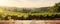 Still life with wine glass on wooden table over background of panoramic view of lush vineyards at sunset