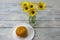 Still life on a wooden table yellow flowers and pumpkin. Light background, selective focus