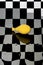 Still life with a yellow balloon on a checkered background