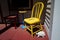 A Still Life of a Yellow Chair, Red Chair, and a Stone Tortoise