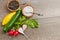 Still life of yellow and green squash, radishes and bowls of salt and pepper