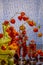 Still life with a yellow vase, a glass of water and a branch of physalis