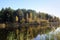 In the still surface of the water of the amazing lake, trees and the sky are reflected.