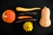 Stilllife with three kinds of pumkins and three kinds of carrots against a black background