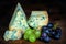 Stilton mature blue mouldy cheese - Dark background and grapes