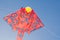 Stingray Kite design in red color flying on blue sky background.