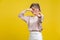 Stinky smell. Portrait of young dissatisfied woman with fair hair in casual beige blouse, isolated on yellow background