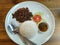 Stir fried beef with basil leafs serve on white plate with steamed rice.