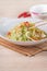 Stir-fried cabbage with sergestid Sakura shrimp in white plate on wooden table background