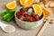 Stir-fried orange ginger tofu with sesame onion and chili spices in a bowl with chopsticks on a table