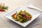 Stir Fried Pork Liver with baby corn, chilli and basil leaves on white plate