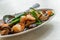 Stir-fried shrimps, Shiitake mushrooms, or Chinese mushrooms with oyster sauce in beautiful oval-shaped plate on the white stone