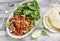 Stir fry of chicken breast and sweet red peppers, fresh spinach and homemade tortillas