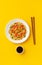 Stir fry noodles with chicken and vegetables on a yellow background. Flat lay. The view from the top