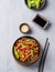 Stir-fry with soba noodles, meat and vegetables on a light background. Asian fast and healthy food concept