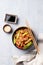 Stir-fry with soba noodles, meat and vegetables on a light background with chopsticks, soy sauce and sesame seeds