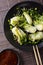 Stir-fry spicy baby bok choy close-up. Vertical top view