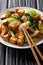 Stir fry tofu with bok choy and sesame seeds close-up on a plate. vertical