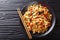 This stir-fry of wide rice noodles with chicken and fresh basil in a spicy, sweet and tangy sauce  close-up on a plate. horizontal