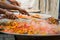 Stirring of cooking ingredients in large frying pans.The giant paella.