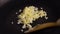 Stirring fried sliced onion in hot frying pan by wooden turner. Close up