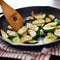 Stirring fried zucchini, in an iron skillet