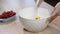 Stirring heavy cream with chocolate pieces in a bowl.