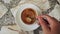 Stirring Milk in Cup of Coffee with Tea Spoon. Top View