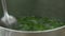 Stirring mint leaves in boiling water with a spoon