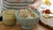 Stirring oatmeal porridge in bowl with fruits and nut butter