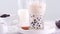 Stirring tasty taiwanese popular drink tapioca pearl bubble milk tea in glass cup on bright marble table white tray, homemade conc