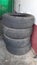 Stock of four old used vehicle tyres in a garage and workshop.