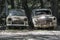 Stock image of two old, rusted, abandoned cars.