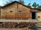 Stock photo of beautiful traditional Indian village house, red brick house with pyramid shape roof top. White color painted stool