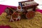 Stock photo of a beautiful traditional Indian wooden bull cart and statue of farmer sitting on bull cart, kept on grains on sunny